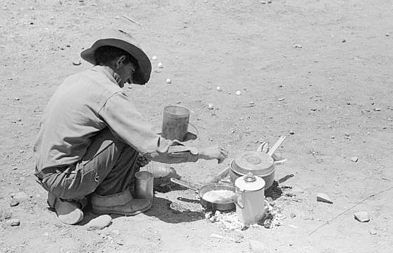 Russell Lee, photographer. Faro Caudill frying eggs over camp fire the day he was moving his dugout. Pie Town, New Mexic