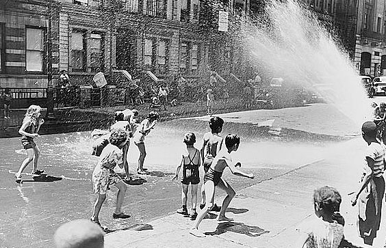 New York, New York. Children escape the heat of the East Side by using fire hydrant as a shower bath. Roger Smith, photo