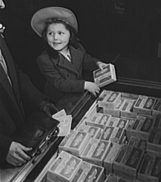 While mother keeps handy her war ration book two, daughter examines the frozen foods which require removal of point stam