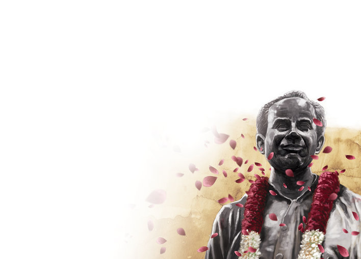 A man honoured with garlands and rose petals
