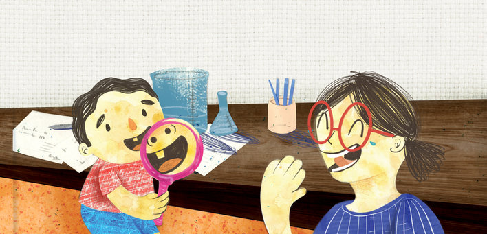 A boy holding a magnifying glass and a girl laughing