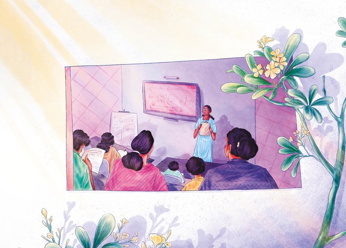 Woman seen teaching science in a classroom through a window adorned with champa flowers