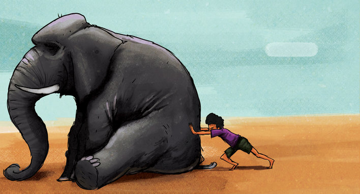 Boy trying to push an elephant