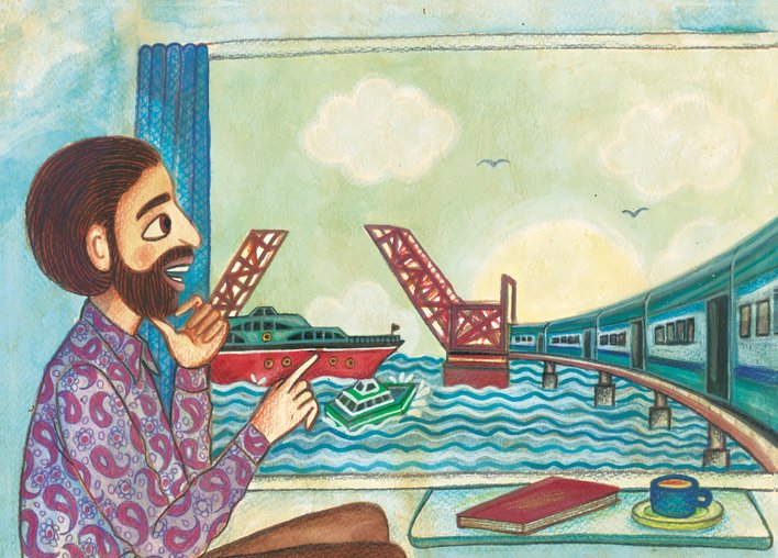 A man looking at the train crossing the bridge across the sea