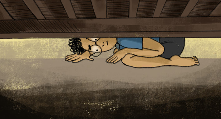 Boy curiously looking under a bed