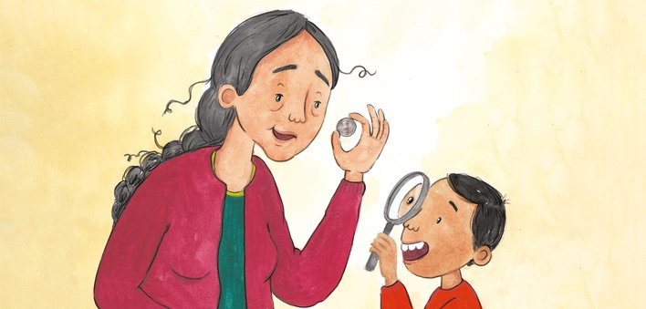 Grandmother and grandson observing a coin through a magnifying glass