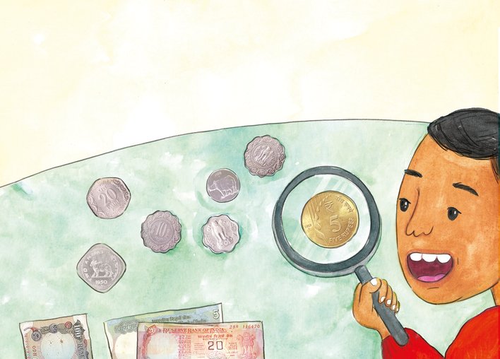 Boy looking at a coin through a magnifying glass