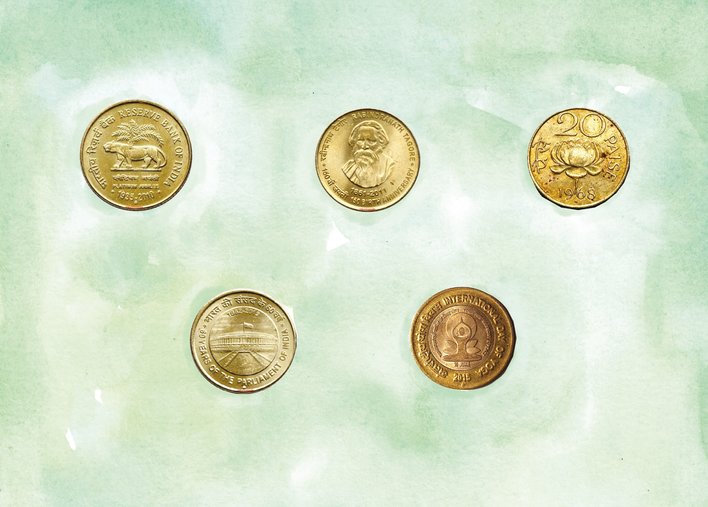 Five unique Indian coins arranged on a table