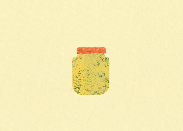 A glass pickle jar waiting to be recycled