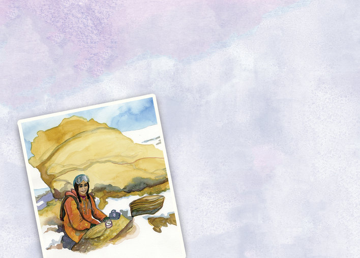 A woman sitting by some rocks