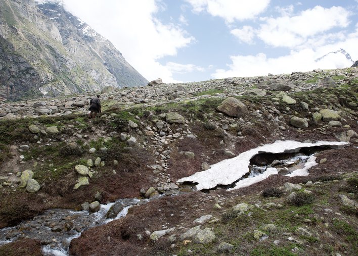 Old man walking beside a melting river