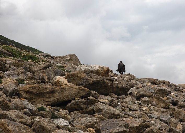 Man walking across rocky terrain