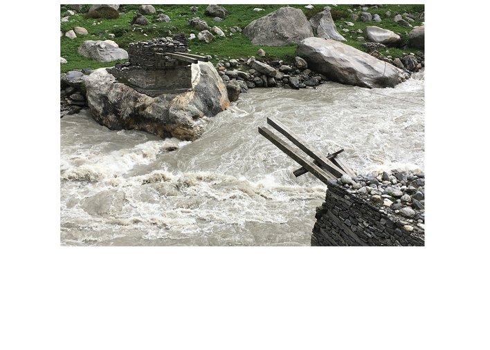 broken bridge over a raging stream